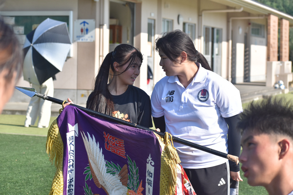 優勝旗を手にするマネージャーたち